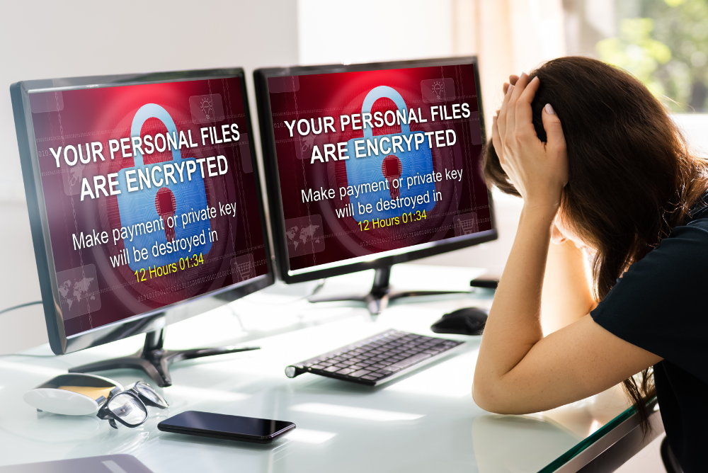 How to Deal with Ransomware Attack.
Ransomware message appearing on 2 computer screens and a lady with her hands on her head.